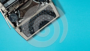 Retro typewriter on blue background with copy space, top view. Literature Blogging Writing Concept