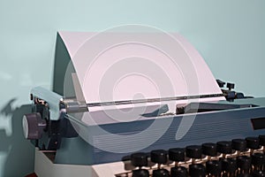 retro typewriter in dark gray and light gray with a white sheet of paper. on a blue background