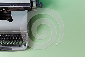 Retro typewriter on green background. Authorship. Journalism. Manual machine with keys for typewriting, copy space photo
