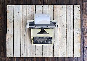 Retro typewriter over vintage wooden background