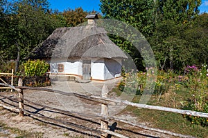 Retro ukrainian cottage with thatched roof and garden