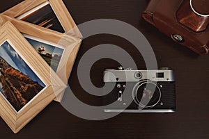 Retro vintage camera and photos in frame on wood background