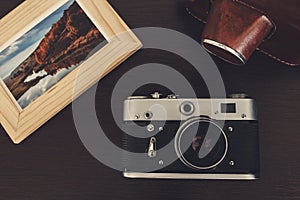 Retro vintage camera and photos in frame on wood background