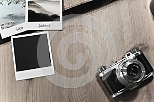 Retro vintage photography concept of three instant photo frames cards on wooden background with old camera and film strip