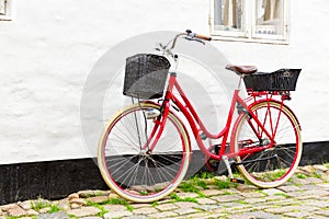 Retro vintage red bicycle on cobblestone street in the old town.