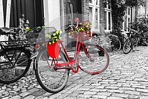 Retro vintage red bicycle on cobblestone street in the old town. photo