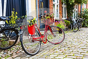 Retro vintage red bicycle on cobblestone street in the old town.