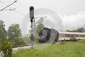 Retro vintage steam locomotive on rail tracks