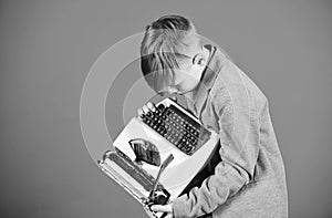 Retro and vintage. Yard sale. Retrospective study. Boy hold retro typewriter on blue background. What to do with this photo