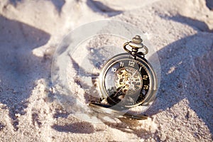 Retro watch on sand. Time concept. History