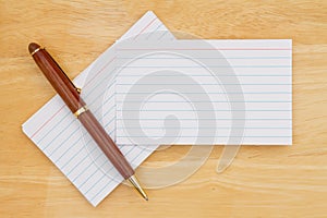 Retro white paper index cards with pen on wood desk