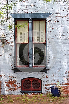 Retro window scene with aged brick and cream shutters.