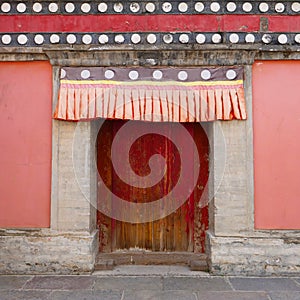 Retro wooden door and wall in Kumbum Monastery, Ta`er Temple a Tibetan Buddhism Monastery in Huangzhong County, Xining Qinghai