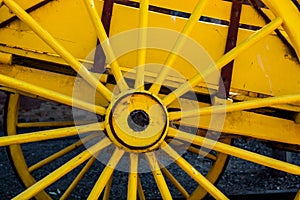 Retro yellow carriage wheel closeup.