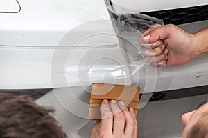 Retrofitting the car with a solid transparent protective film, the master glues the coating protecting the vehicles from scratches