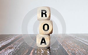 Return on Asset. ROA the word on wooden cubes, cubes stand on a reflective surface