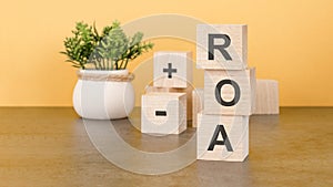 return on assets ROA the word on wooden cubes, cubes stand on a reflective surface, in the background is a business