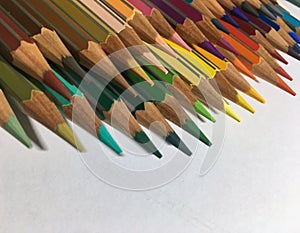 Return back to school. Close up of colored sharpened pencils on white background. Colorful concept