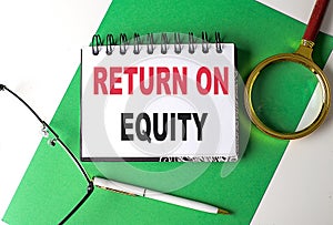 RETURN ON EQUITY text on notebook on green paper