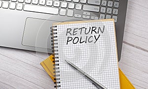 RETURN POLICY text written on a notebook on the laptop,business photo