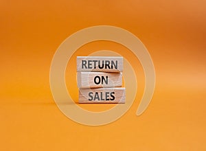 Return on Sales symbol. Concept word Return on Sales on wooden blocks. Beautiful orange background. Business and Return on Sales