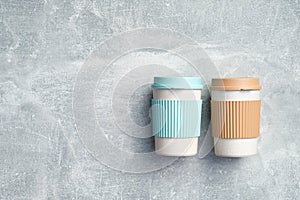 Reusable bamboo coffee cups on stone background. Eco-friendly take away coffee mugs. Zero waste, sustainable lifestyle concept.