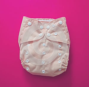 Reusable cloth baby diaper. Eco friendly nappy on pink background