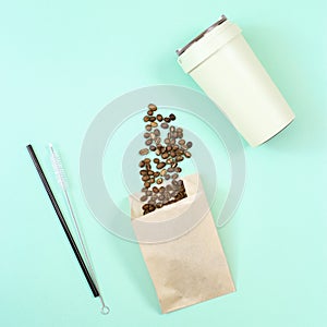 Reusable eco coffee cup, metal drinking straw, roasted coffee beans in papaer bag