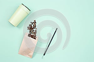 Reusable eco coffee cup, roasted coffee beans and metal drinking straw. Zero waste concept