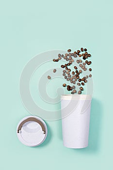 Reusable eco coffee cup with roasted coffee beans