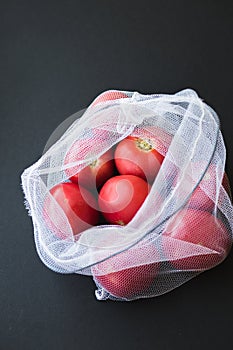 Reusable eco-friendly bag full of fresh seasonal tomatoes