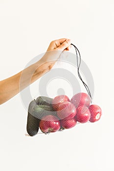 Reusable eco-friendly bag full of fresh seasonal tomatoes and cucumber