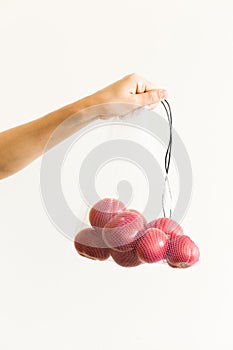 Reusable eco-friendly bag full of fresh seasonal tomatoes on white background