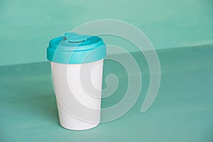 Reusable eco-friendly bamboo cup on mint green background