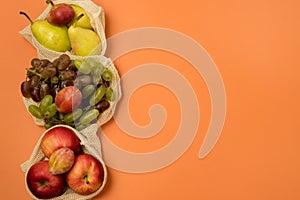 Reusable Grocery Bags With Fruits Reusable Packaging for Fruits and Vegetables Zero Waste Concept Orange Background Top View Copy