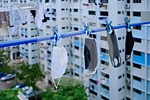 Reusable masks washed and hung on laundry pole to dry; eco-friendly, reusable homemade cloth masks, biocompatible supermask PM2.5