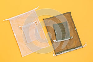 A reusable mesh bags for grocery shopping filled on yellow background