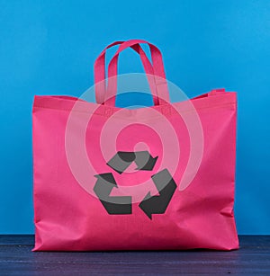 Reusable pink viscose bag on blue wooden background