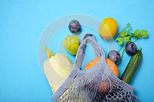 Reusable shopping String bag, open netted bag with fresh apples. blue Mesh shopping bag with fruits on green shadow background.