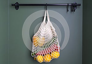 A reusable shopping string bag with vegetables and fruit from the supermarket. Single-use plastic bag ban concept. Zero