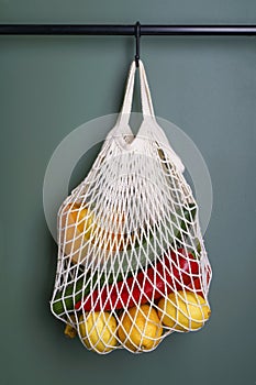 A reusable shopping string bag with vegetables and fruit from the supermarket. Single-use plastic bag ban concept. Zero