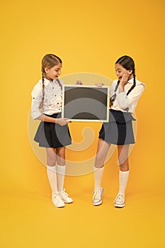 A reusable writing surface. Little children preparing blackboard for lesson. Small pupils with school blackboard. Cute