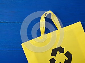 Reusable yellow viscose bag on blue wooden background