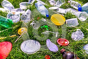 Reuse garbage, recycle, plastic free. Food plastic packaging, trash on green grass background. Recycling plastic