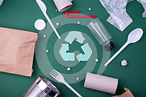 Reuse reduce recycle flat lay concept with plastic, paper, and polyethylene waste. Ecology background image with recycling symbol