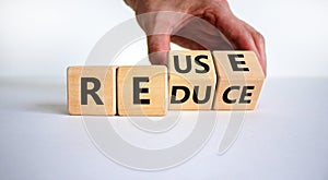 Reuse or reduce symbol. Businessman turns wooden cubes and changes the words reduce to reuse. Beautiful white background, copy