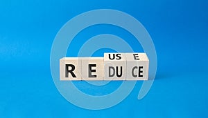 Reuse or Redue symbol. Turned wooden cubes with words reduce and reuse. Beautiful blue background. Business and Reuse and Reduce