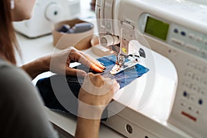 Reuse, repair, upcycle. Denim upcycling ideas, repair and using old jeans. Close-up of sewing machine with shabby, old