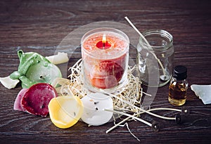 Reusing old candles leftovers and making melting a new one: various ingredients on table: candle wicks, glass jar, old candles wax