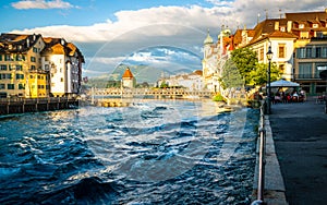 Reuss river turbulent water view in middle of Lucerne old town with the Chapel bridge and Rigi mount in background Lucerne